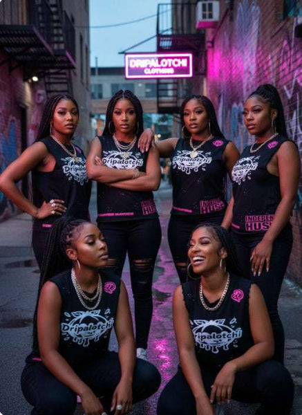 Group of women wearing matching black outfits with visible branding on a city street.